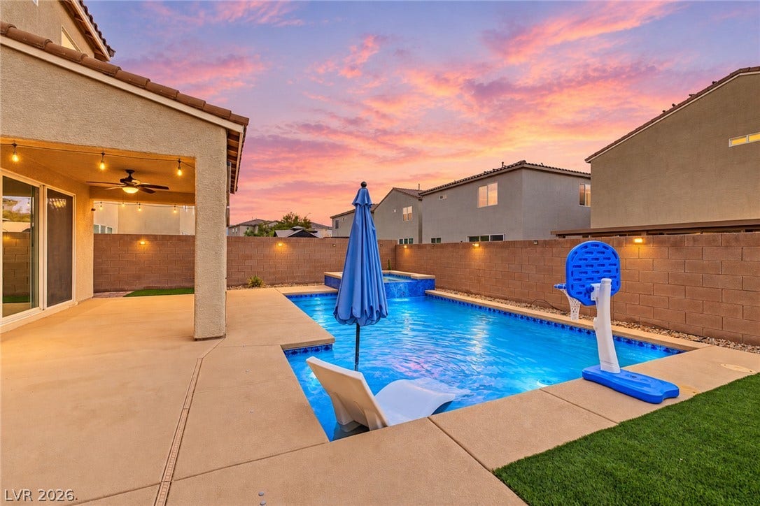 4618 Summer Azure Street, North Las Vegas, NV 89031 An inviting backyard oasis features a concrete patio alongside a shimmering swimming pool.