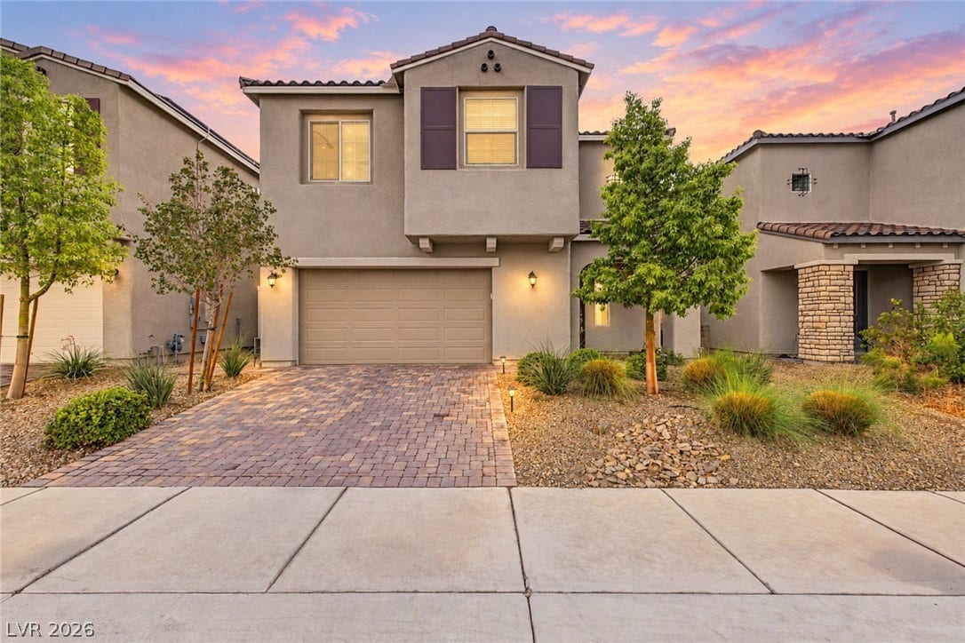 4618 Summer Azure Street, North Las Vegas, NV 89031 An inviting stone-paved driveway leads to a modern two-story home with desert-inspired landscaping.