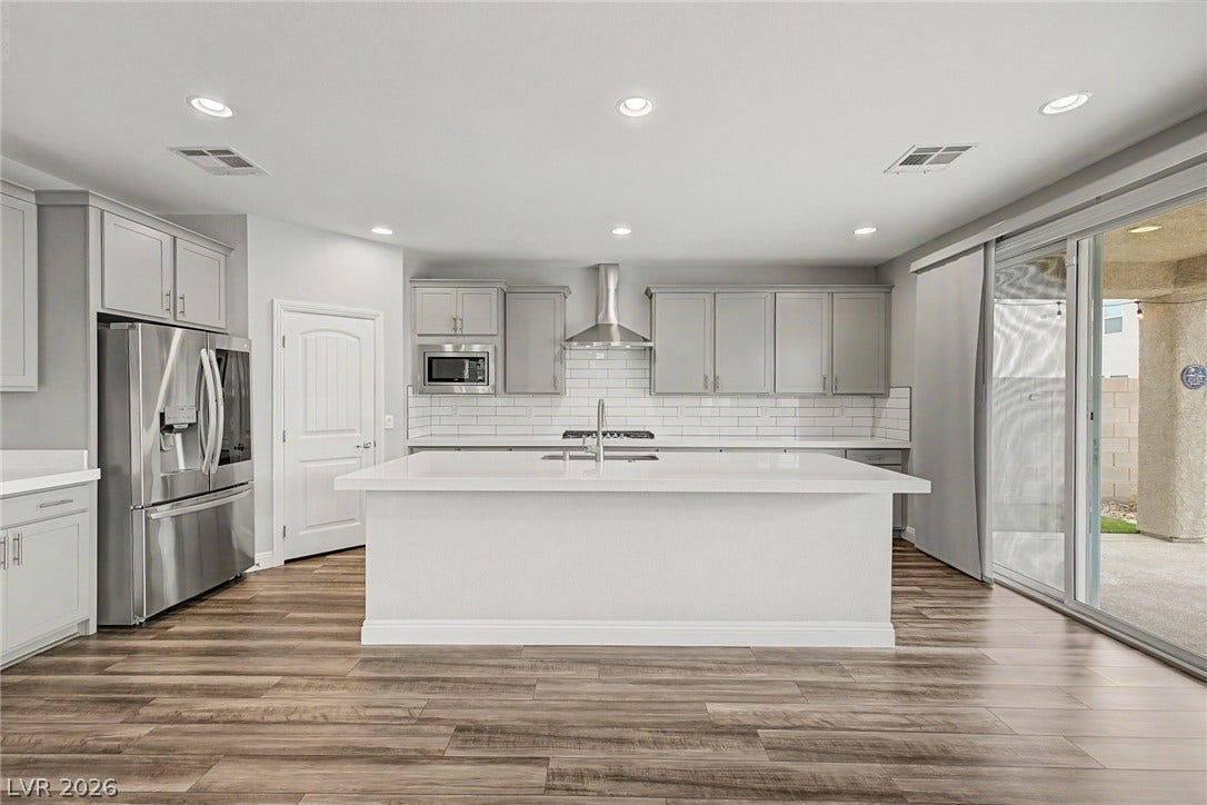 4618 Summer Azure Street, North Las Vegas, NV 89031 Warm wood flooring pairs beautifully with clean cabinetry and sliding glass doors to the patio.