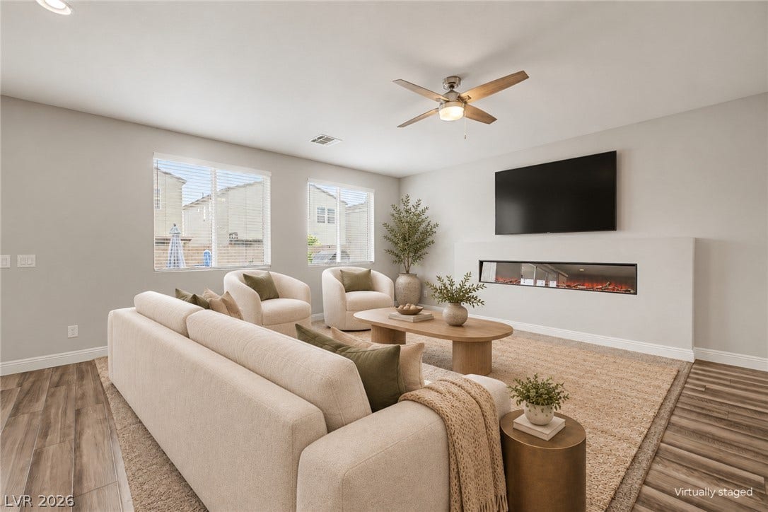 4618 Summer Azure Street, North Las Vegas, NV 89031 Rich wood-look flooring and a modern linear fireplace anchor this inviting living space.