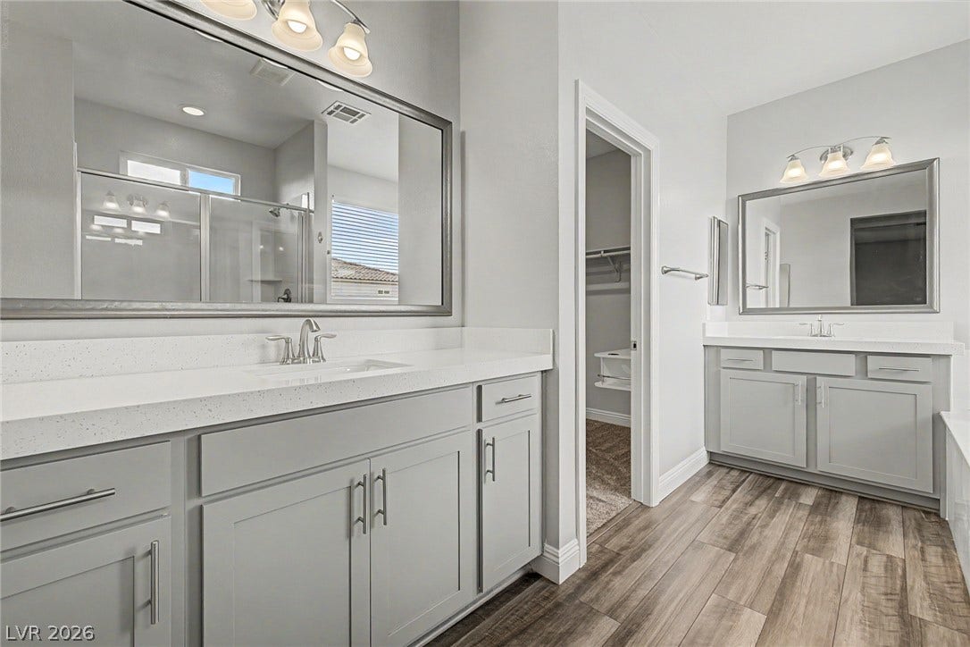 4618 Summer Azure Street, North Las Vegas, NV 89031 Dual vanities with stone counters flank the entrance to a walk-in closet.