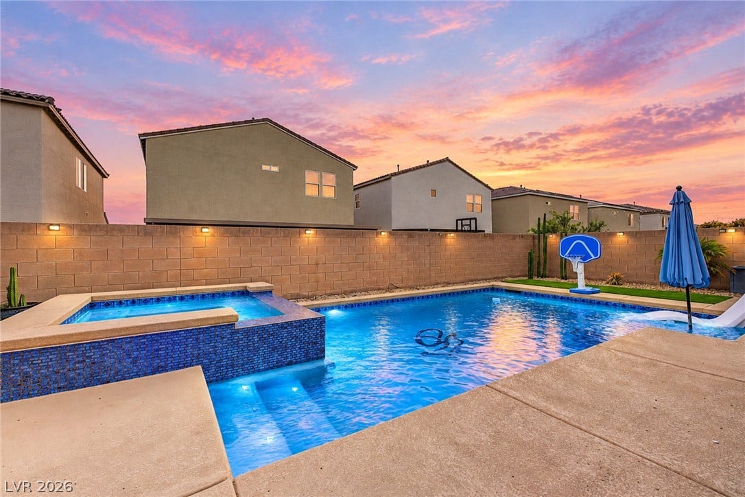 4618 Summer Azure Street, North Las Vegas, NV 89031 An inviting backyard swimming pool and spa sit framed by a clean concrete patio.