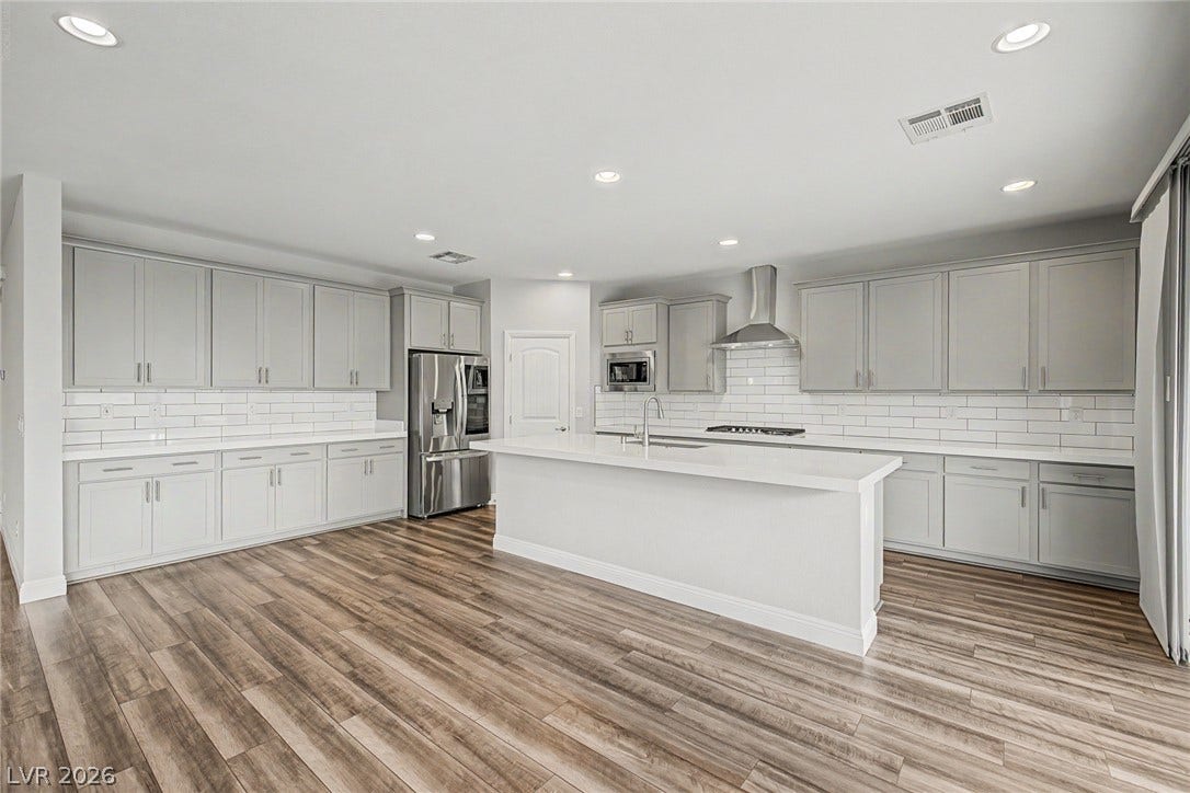 4618 Summer Azure Street, North Las Vegas, NV 89031 Gleaming wood-look floors anchor this expansive kitchen featuring a central island and timeless subway tile.