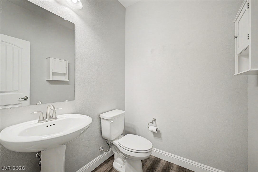 4618 Summer Azure Street, North Las Vegas, NV 89031 Clean lines and classic fixtures define this half bath with wood-look flooring.