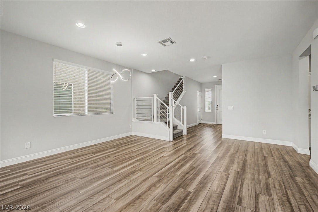 4618 Summer Azure Street, North Las Vegas, NV 89031 Rich wood-look flooring and recessed lighting define this versatile open living space.