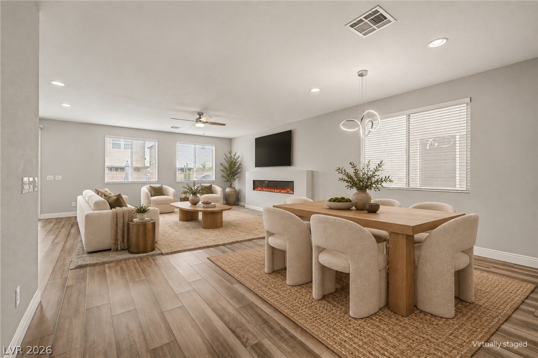4618 Summer Azure Street, North Las Vegas, NV 89031 An open floor plan seamlessly connects the dining area to a fireplace-centered living space.