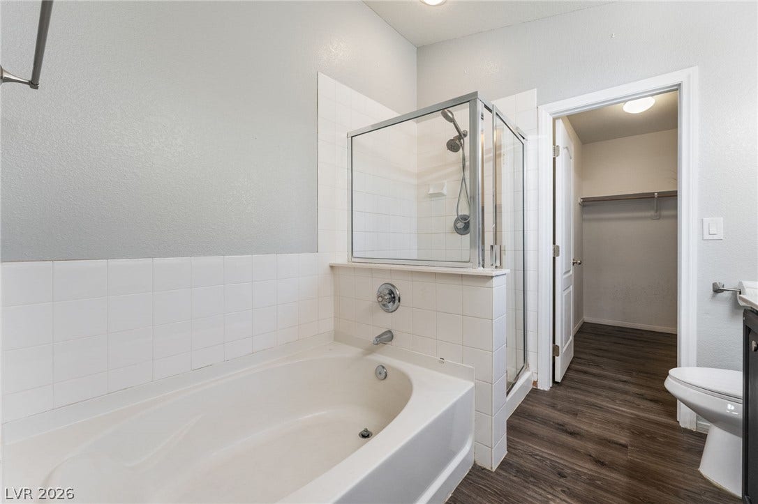 6527 Velvet Silk Street, North Las Vegas, NV 89084 A spacious soaking tub pairs with a glass-enclosed shower, leading directly to a walk-in closet.