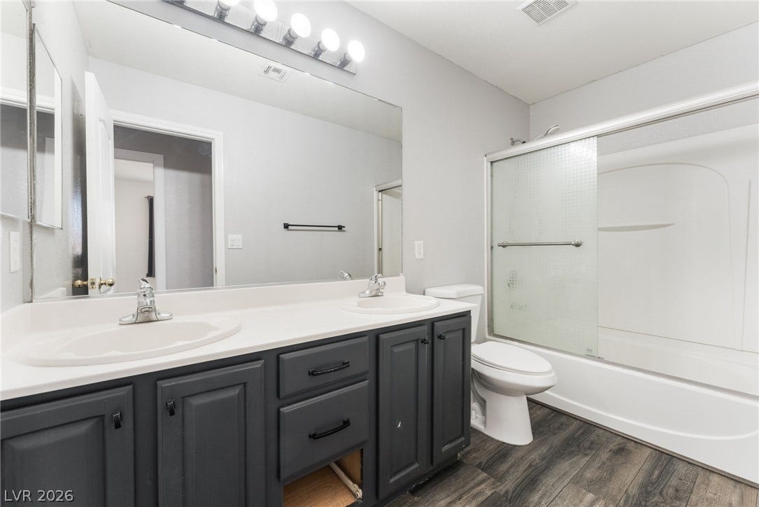 6527 Velvet Silk Street, North Las Vegas, NV 89084 Double vanity highlights this clean guest bathroom setup with a tub and shower combination.