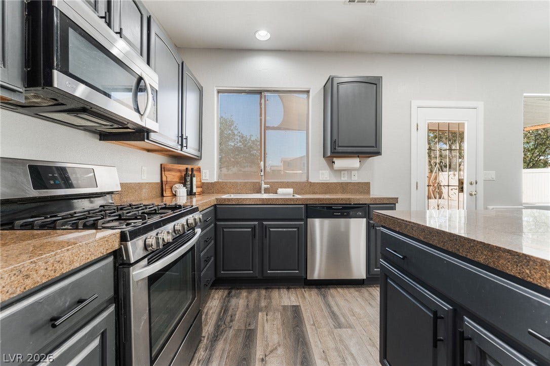 6527 Velvet Silk Street, North Las Vegas, NV 89084 Richly toned cabinetry and durable countertops define this efficiently designed workspace with modern appliances.