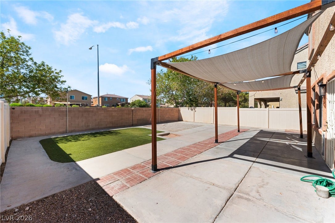 6527 Velvet Silk Street, North Las Vegas, NV 89084 A spacious backyard patio features shade sails over a paved area. Plenty of room to entertain.