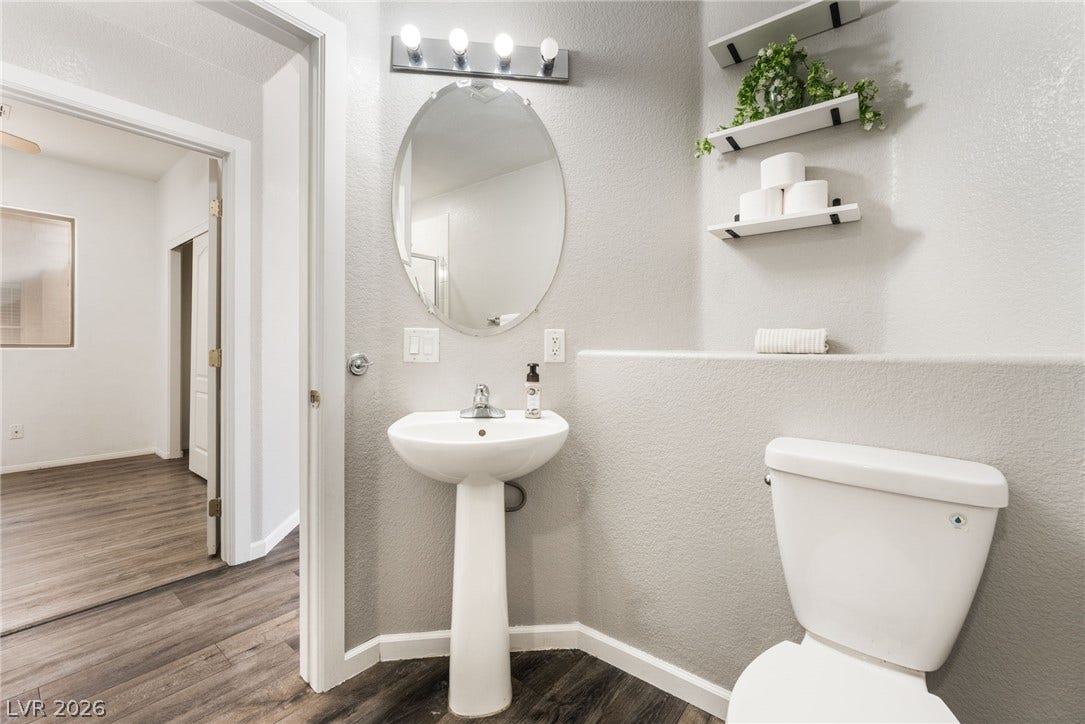 6527 Velvet Silk Street, North Las Vegas, NV 89084 Pedestal sink and neutral wall finishes define this downstairs bathroom.