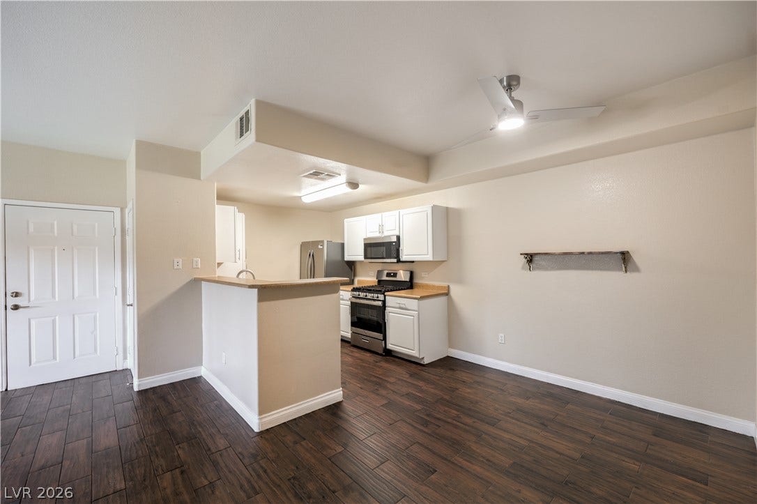 8250 N Grand Canyon Drive, #1006, Las Vegas, NV 89166 Rich wood-look flooring anchors this open living space leading into a classic corner kitchen.