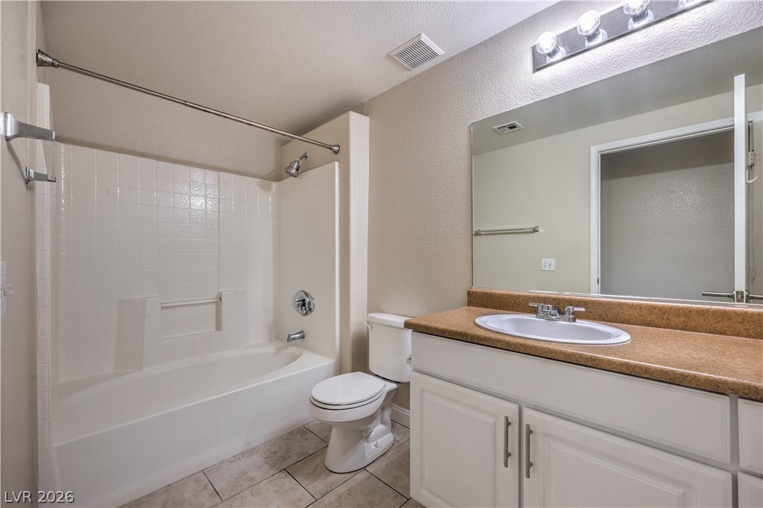 8250 N Grand Canyon Drive, #1006, Las Vegas, NV 89166 Tiled flooring and a modern vanity highlight this functional bathroom space.