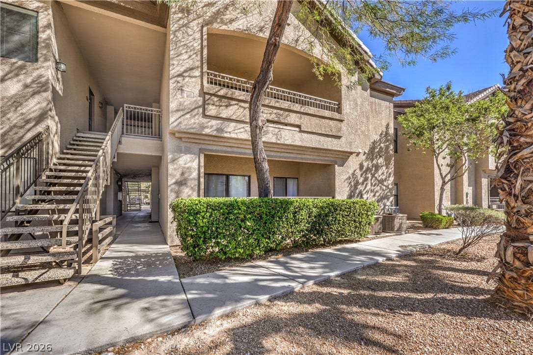 8250 N Grand Canyon Drive, #1006, Las Vegas, NV 89166 Concrete walkways lead past manicured hedges to covered entries and private patios.