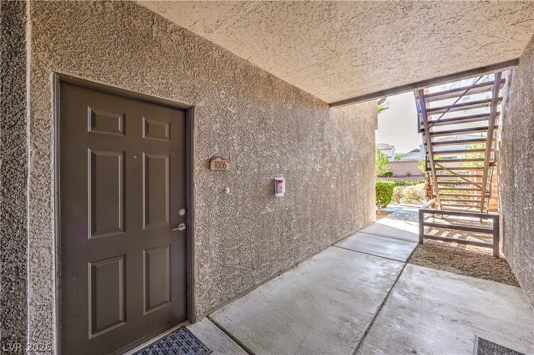 8250 N Grand Canyon Drive, #1006, Las Vegas, NV 89166 A private entrance sheltered by a concrete corridor opens to the outdoor walkway.