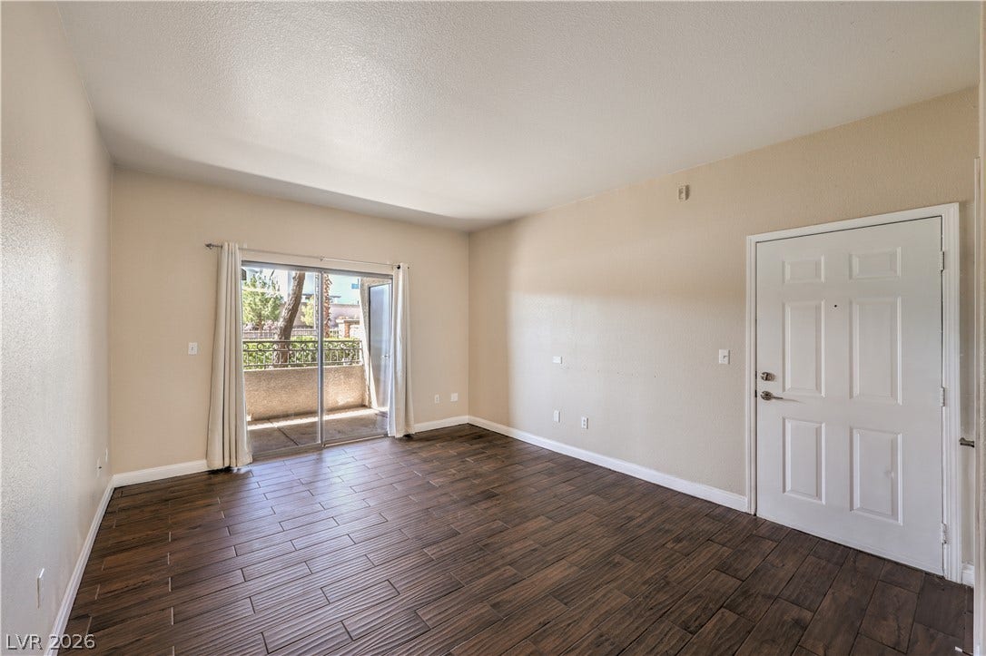 8250 N Grand Canyon Drive, #1006, Las Vegas, NV 89166 Rich wood-look tile floors anchor this versatile room, opening directly to a private outdoor patio.