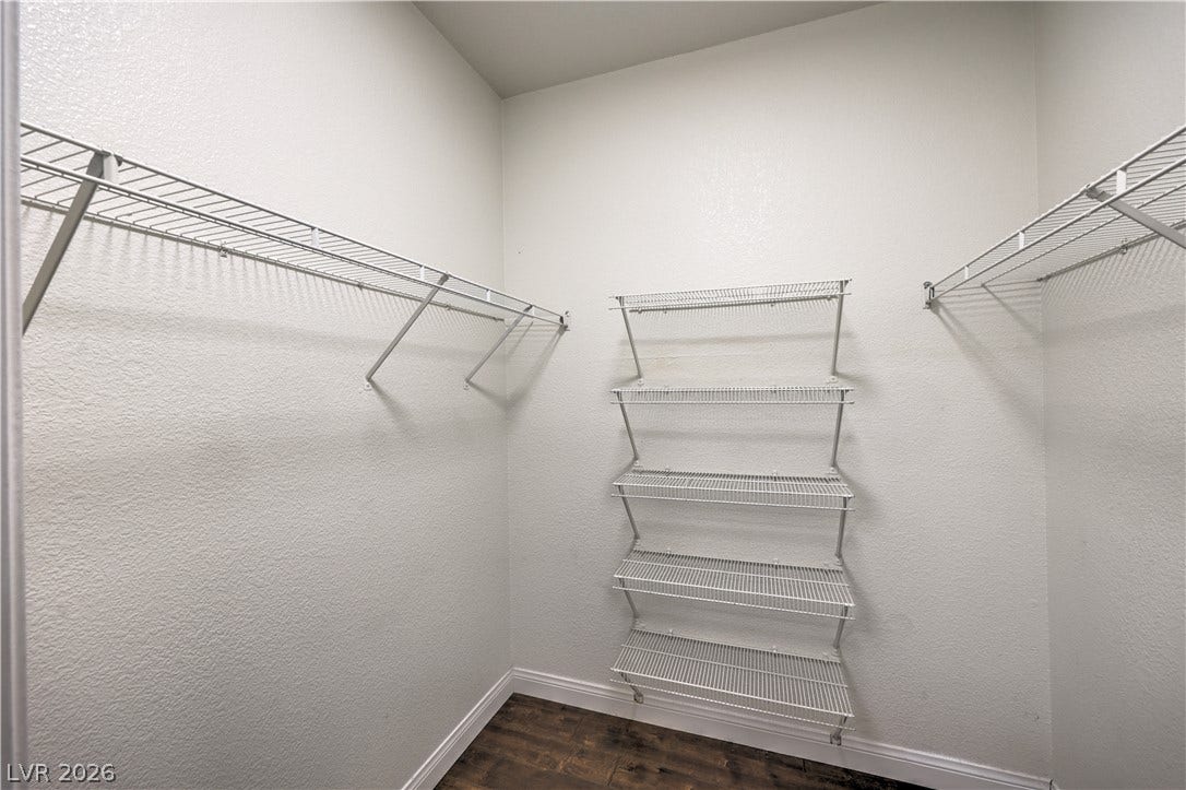 8250 N Grand Canyon Drive, #1006, Las Vegas, NV 89166 Ample wire shelving lines this functional walk-in closet space with dark wood flooring.