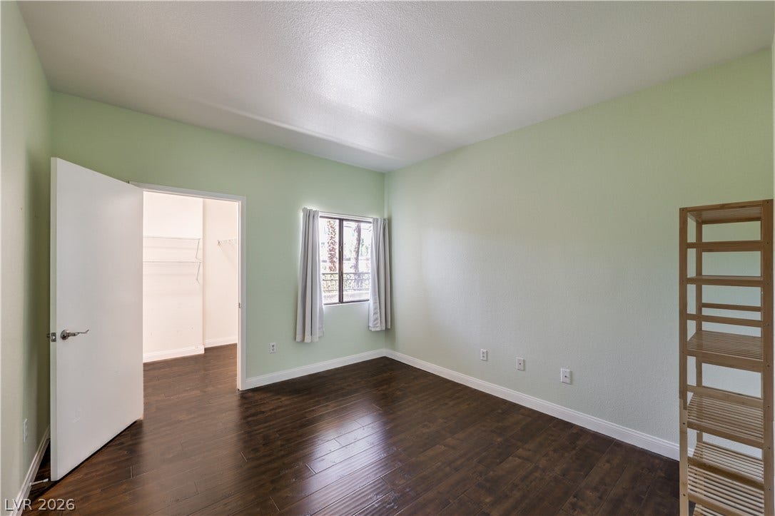 8250 N Grand Canyon Drive, #1006, Las Vegas, NV 89166 Rich hardwood flooring anchors this versatile bedroom featuring a connected walk-in closet.