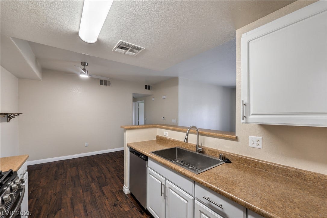8250 N Grand Canyon Drive, #1006, Las Vegas, NV 89166 Rich wood flooring runs through the cooking area into an adjacent living space.
