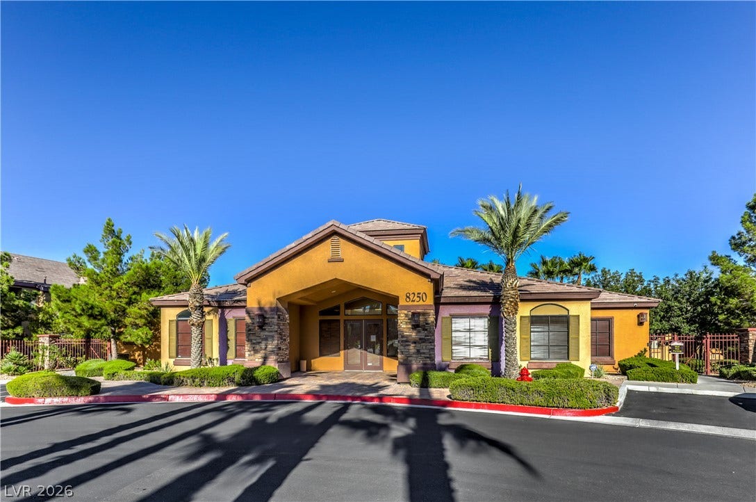 8250 N Grand Canyon Drive, #1006, Las Vegas, NV 89166 Palm trees frame the arched entryway of this striking southwest style exterior.