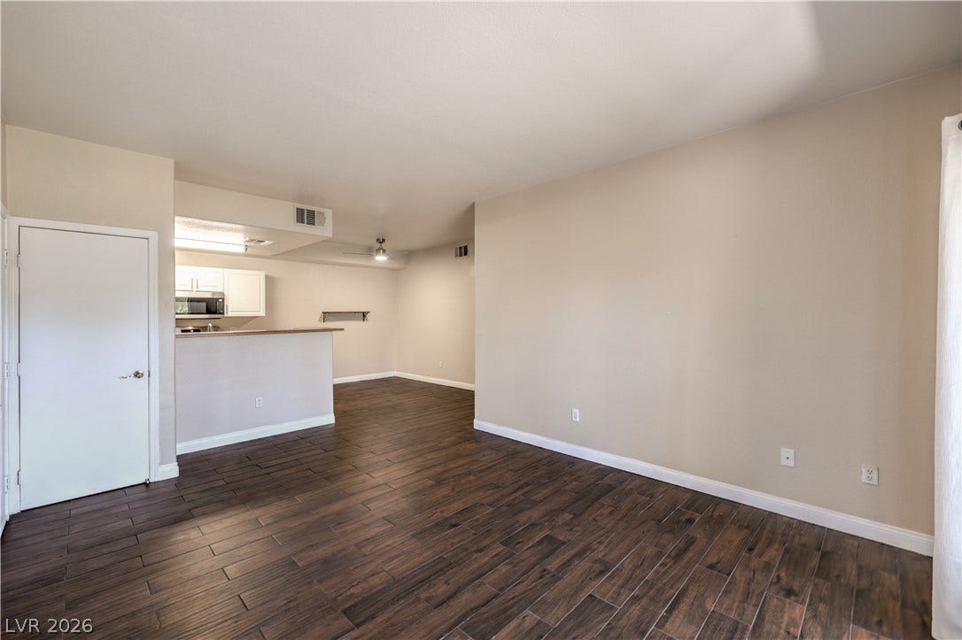8250 N Grand Canyon Drive, #1006, Las Vegas, NV 89166 Rich wood-look flooring anchors this open living space flowing seamlessly toward the kitchen area.