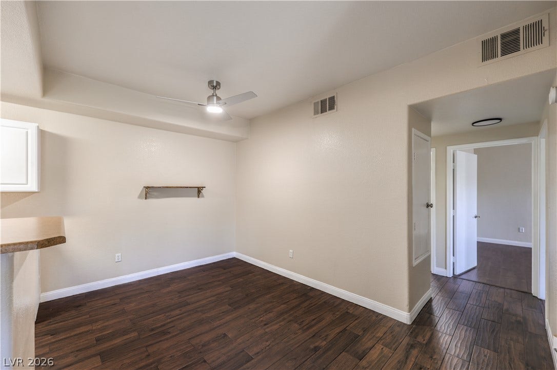 8250 N Grand Canyon Drive, #1006, Las Vegas, NV 89166 Rich wood-look flooring anchors this versatile space, opening seamlessly to adjacent hallways.