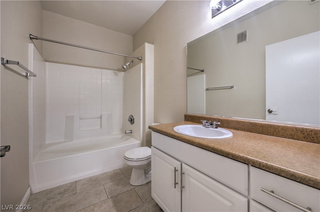 8250 N Grand Canyon Drive, #1006, Las Vegas, NV 89166 An inviting bathroom displays a modern tiled tub surround and clean vanity space.