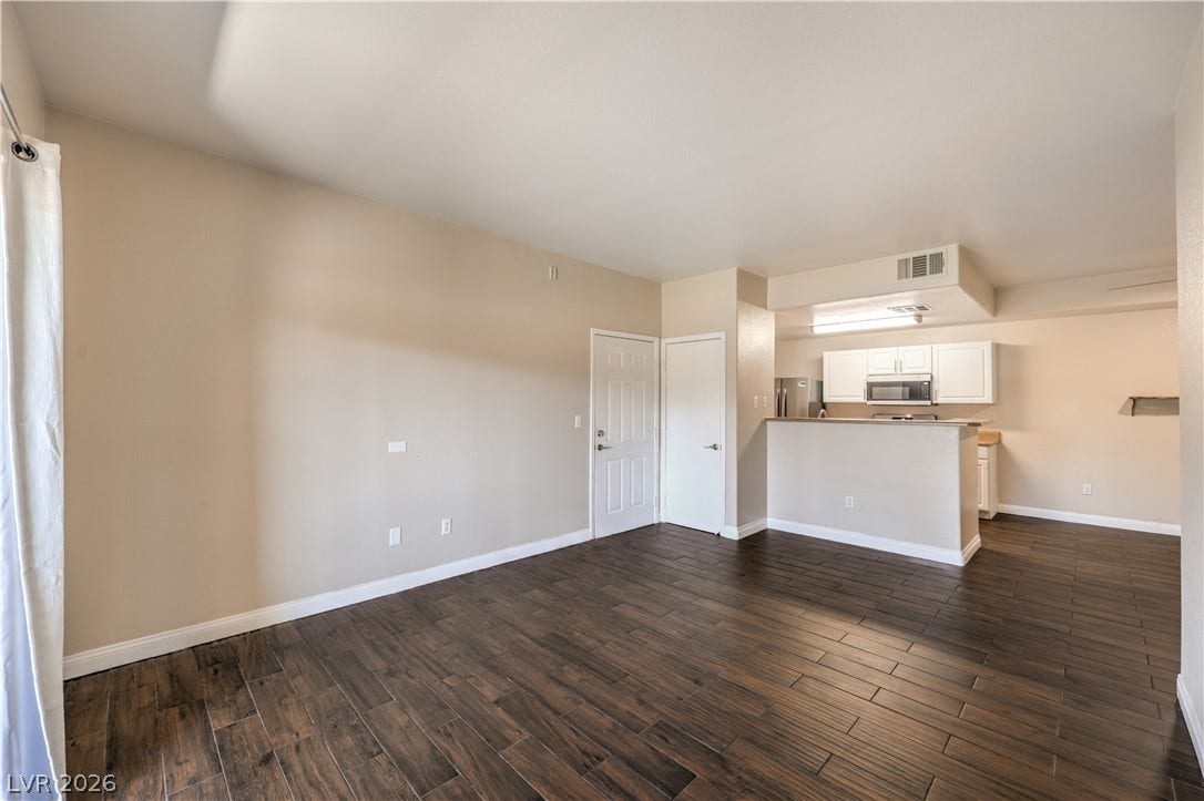 8250 N Grand Canyon Drive, #1006, Las Vegas, NV 89166 Rich wood-look flooring anchors this open living space flowing seamlessly into the kitchen.