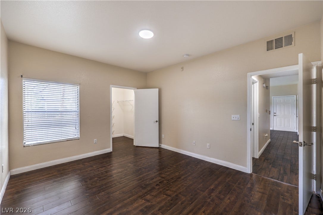 8250 N Grand Canyon Drive, #1006, Las Vegas, NV 89166 Rich wood-look flooring and a walk-in closet highlight this versatile bedroom space.