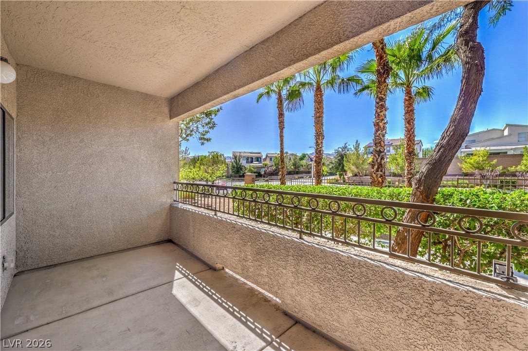 8250 N Grand Canyon Drive, #1006, Las Vegas, NV 89166 Shaded concrete balcony offers tranquil views of manicured landscaping and towering palm trees.