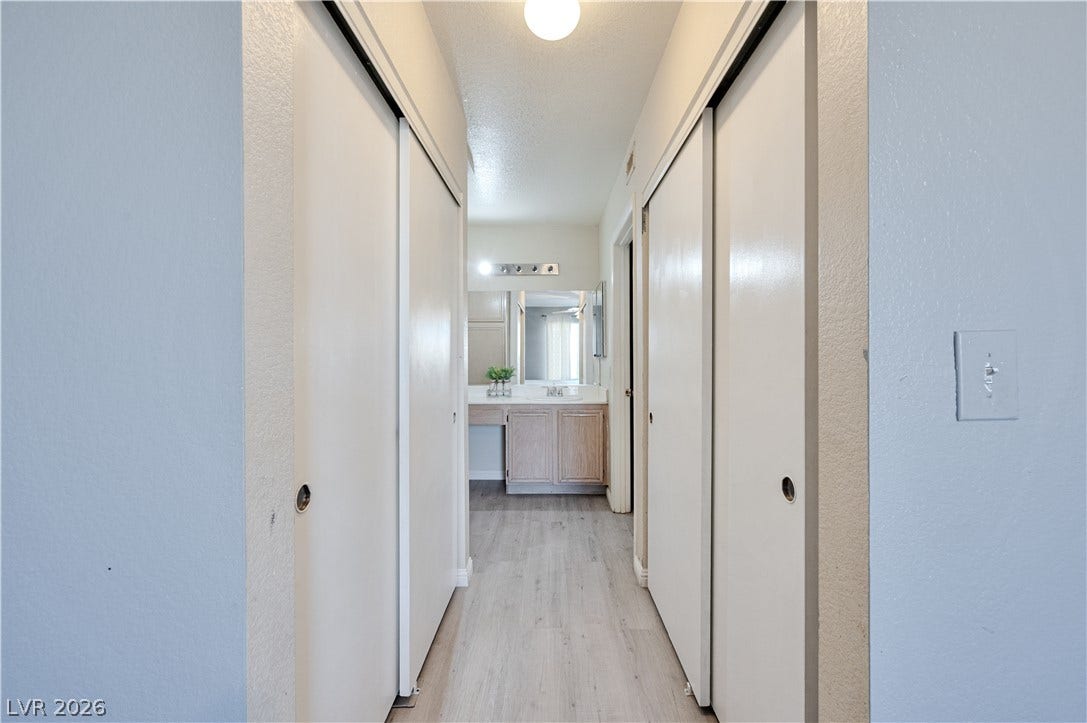 A straightforward hallway layout connects functional closets directly to an adjacent vanity area.