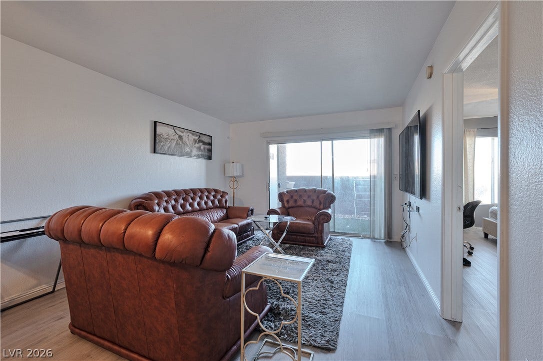 A sliding glass door opens to the private patio from this inviting living area.