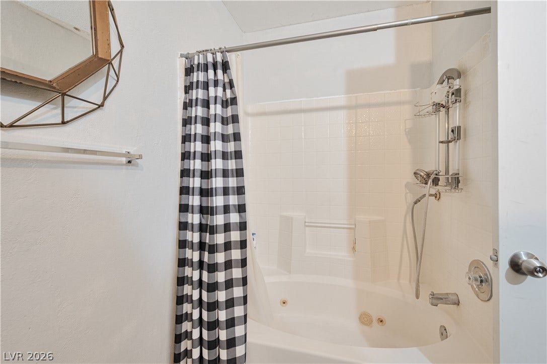 Tiled walls and a deep soaking tub create a functional bathing space.