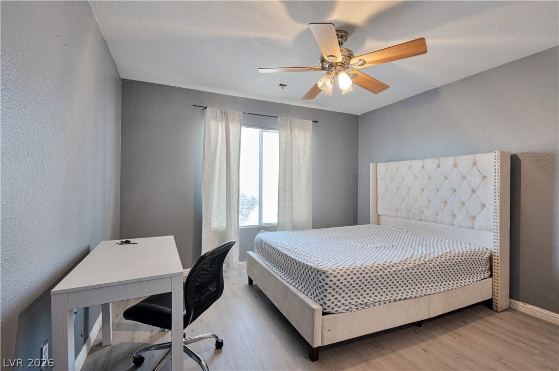 Smooth plaster finishes pair with wood-style flooring in this restful bedroom retreat.