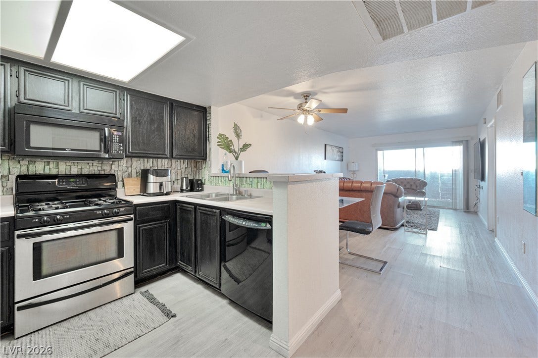 An open floorplan seamlessly connects the functional kitchen space to the adjoining living area.