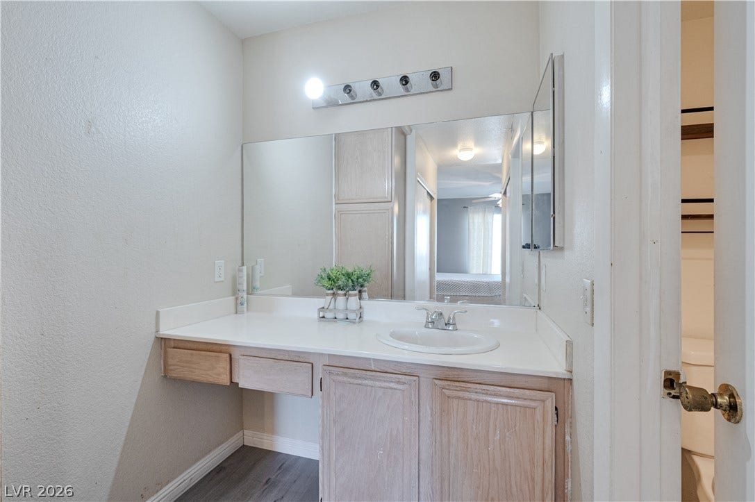 A spacious vanity area with built-in cabinetry provides ample prep space.