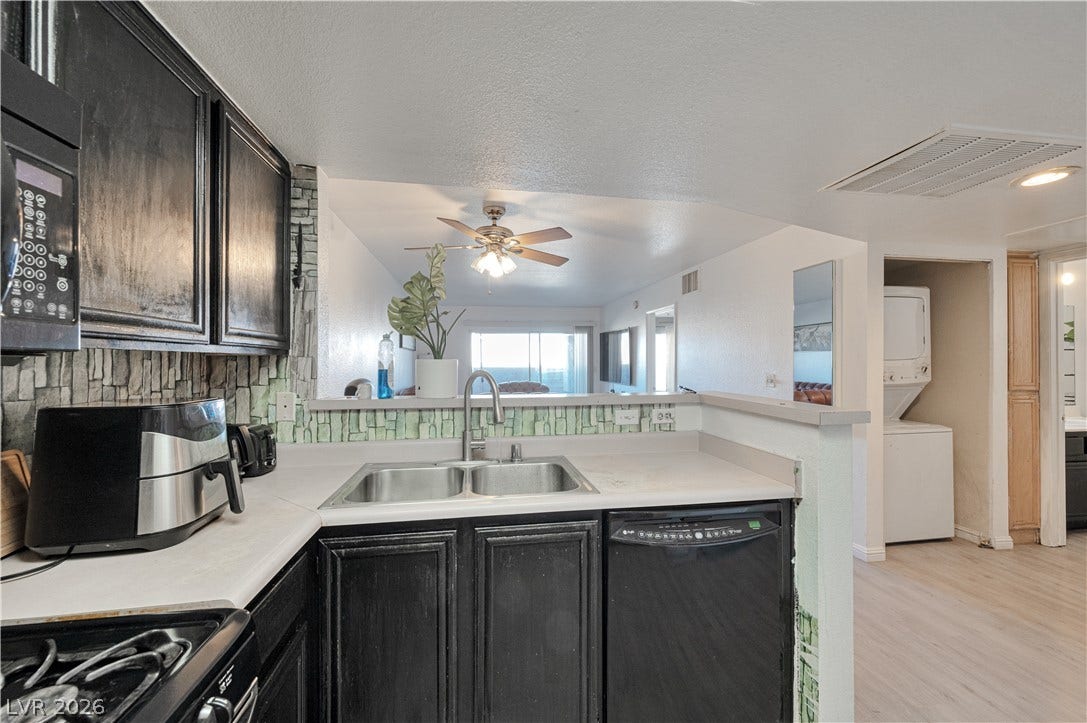 Dark cabinetry and a breakfast bar opening to the living area define this kitchen.