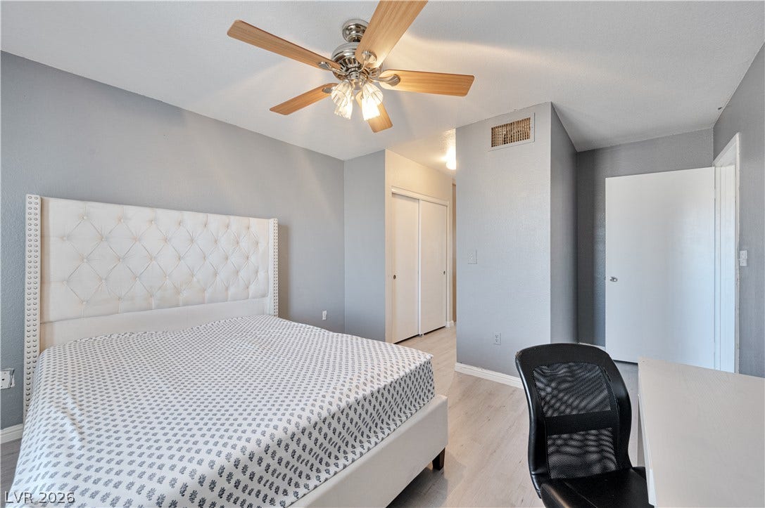Smooth wood floors and neutral walls anchor this serene sleeping space.