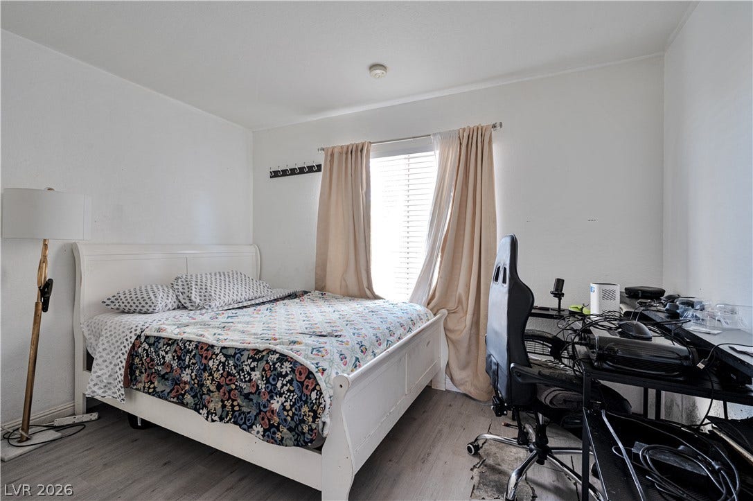 Natural light pours through a large window illuminating this versatile bedroom space.