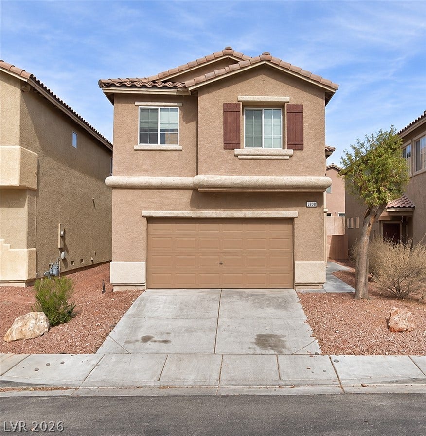 3808 Carisbrook Drive, North Las Vegas, NV 89081 Two-story home features a tiled roof, stucco exterior, and attached garage alongside desert landscaping.