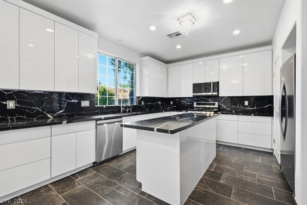 9726 Sweet Jasmine Drive, Las Vegas, NV 89148 Glossy white cabinetry contrasts elegantly with dark stone countertops and matching tiled floors.