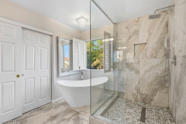 9726 Sweet Jasmine Drive, Las Vegas, NV 89148 Polished tile floors meet a seamless glass shower and deep freestanding tub under natural light.