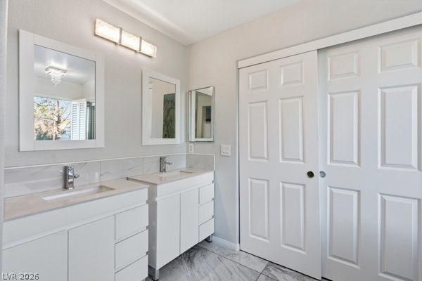 9726 Sweet Jasmine Drive, Las Vegas, NV 89148 Gleaming tile floors complement modern dual vanities in this sleek, updated bathroom.