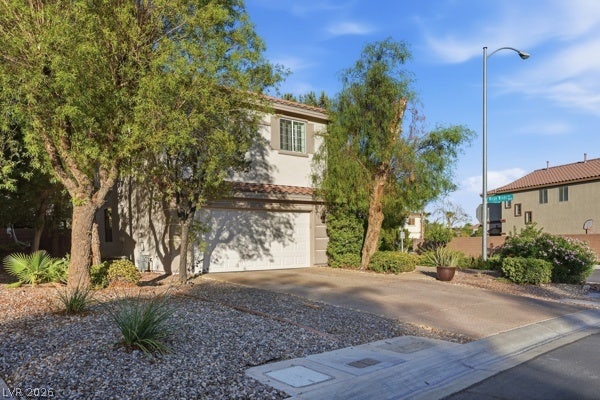 9726 Sweet Jasmine Drive, Las Vegas, NV 89148 Mature trees frame the driveway and classic exterior of this two-story residential design.