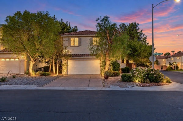 9726 Sweet Jasmine Drive, Las Vegas, NV 89148 Mature trees and neat landscaping frame this two-story exterior featuring a tile roof.