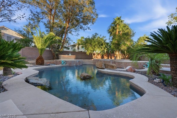 9726 Sweet Jasmine Drive, Las Vegas, NV 89148 Mature palms and lush foliage border a custom swimming pool with natural rock accents.