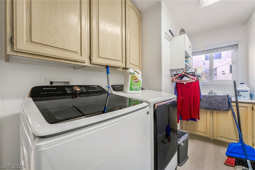 125 Heather Drive, Henderson, NV 89002 A functional laundry space features wood cabinetry, a utility sink, and natural window light.