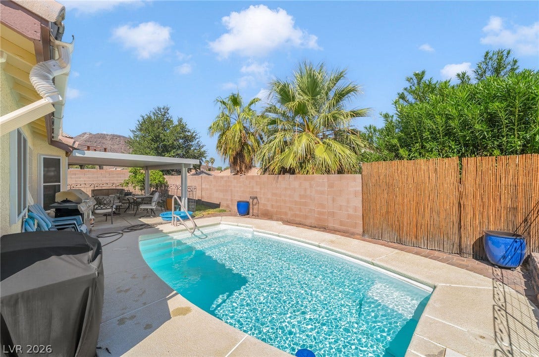 125 Heather Drive, Henderson, NV 89002 An inviting backyard oasis features a shimmering inground pool surrounded by concrete decking and privacy fencing.