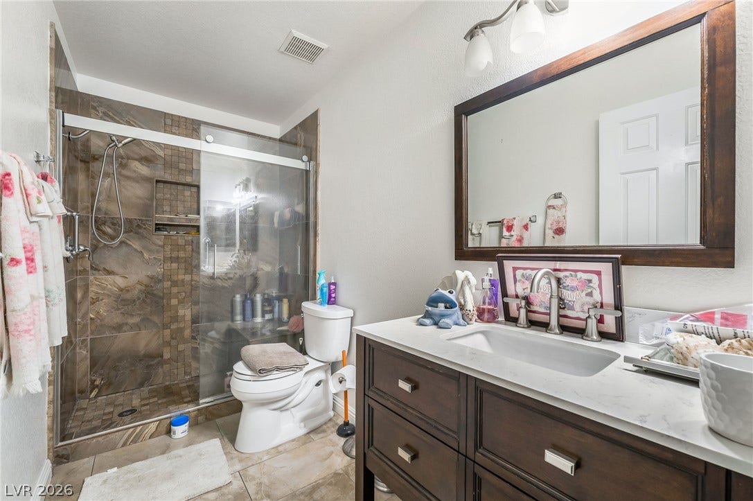 125 Heather Drive, Henderson, NV 89002 Richly tiled walk-in shower highlights this functional bathroom space.