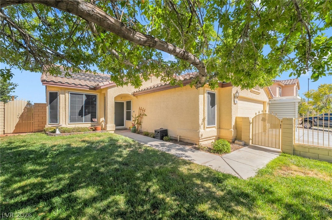125 Heather Drive, Henderson, NV 89002 Mature trees shade a welcoming paved pathway leading to the stucco exterior and gated entry.